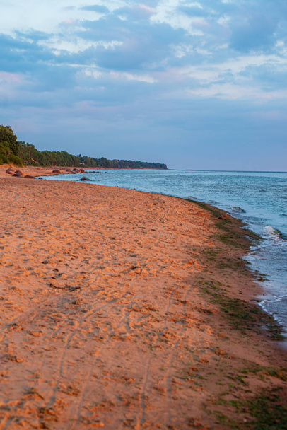 Einsamer leerer Meeresstrand mit weißem Sand, großen Felsen und altem Holz - Foto, Bild