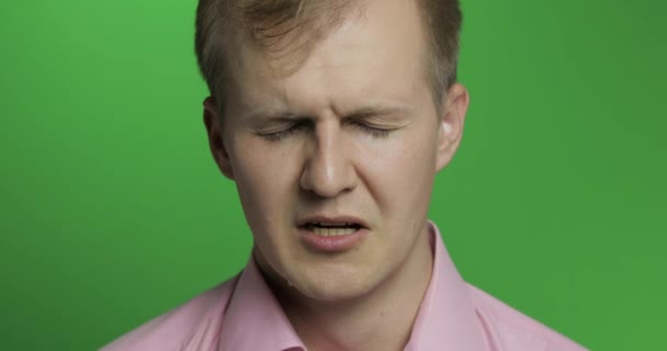 Twarz młodego mężczyzny przygnębiającego płacz na zielonym tle klucza Chroma - Materiał filmowy, wideo