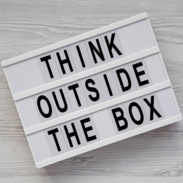Tablero moderno con palabras 'Piensa fuera de la caja' en un bosque blanco
 - Foto, Imagen