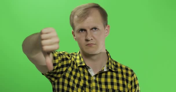 Valkoihoinen nuori mies keltaisessa paidassa osoittaa ei ja antaa peukalonsa alas
 - Materiaali, video