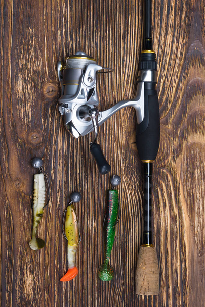 different parts of the spinning for fishing lies on a burnt wooden background - Fotoğraf, Görsel