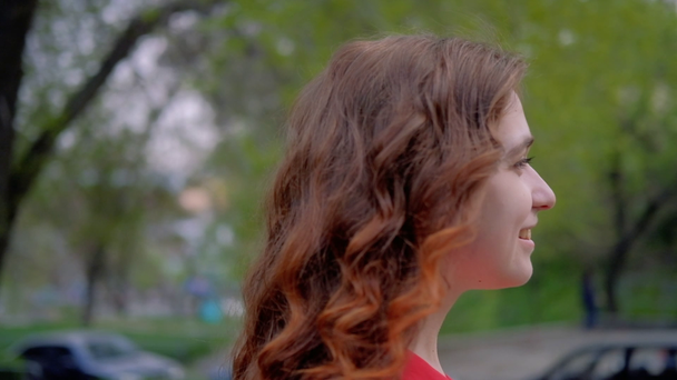 zelfverzekerd Glimlachende vrouw lopen rood krullend haar - Video