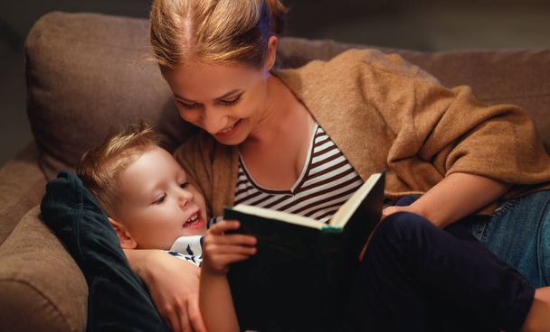 Rodzina przed chodzenie do łóżko matka czyta do jej dziecko syn książka ne - Zdjęcie, obraz