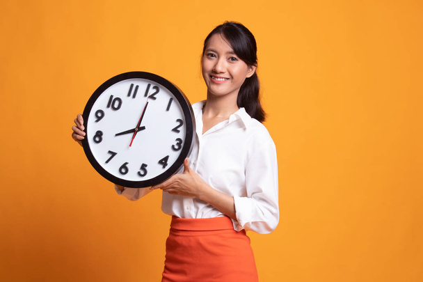 Young Asian woman with a clock. - Fotografie, Obrázek