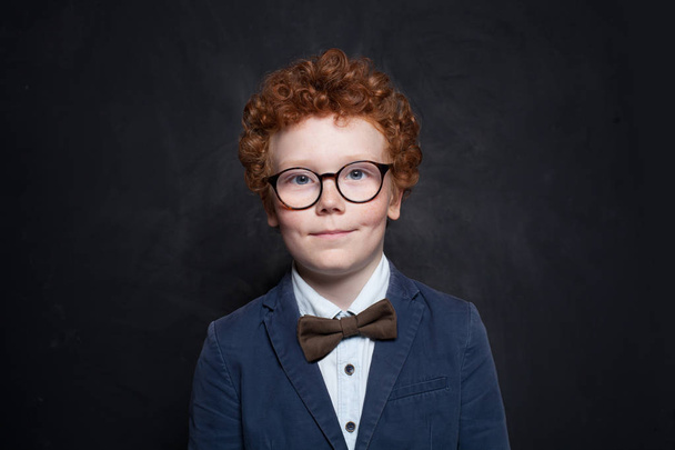 Симпатичний хлопчик у костюмі та краватці в класі на дошці
  - Фото, зображення