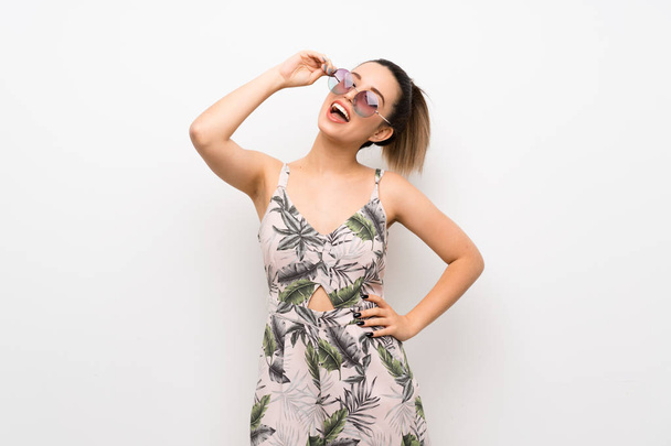 Young woman over isolated white background with glasses and smiling - 写真・画像
