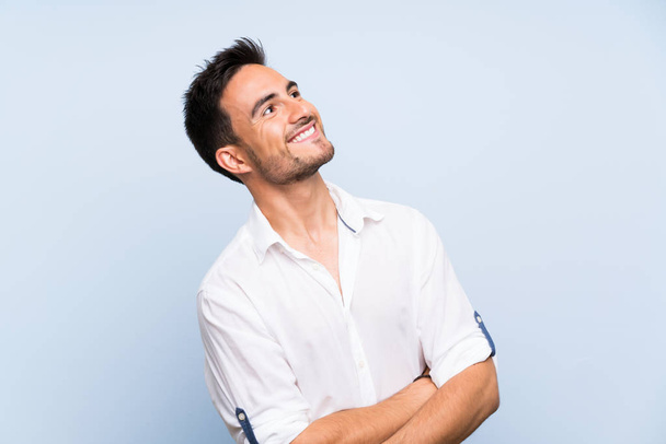 Handsome young man over isolated blue background smiling - Photo, Image