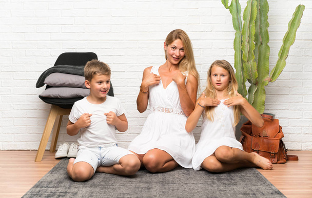 Madre con i suoi due figli in casa facendo gesto a sorpresa
 - Foto, immagini