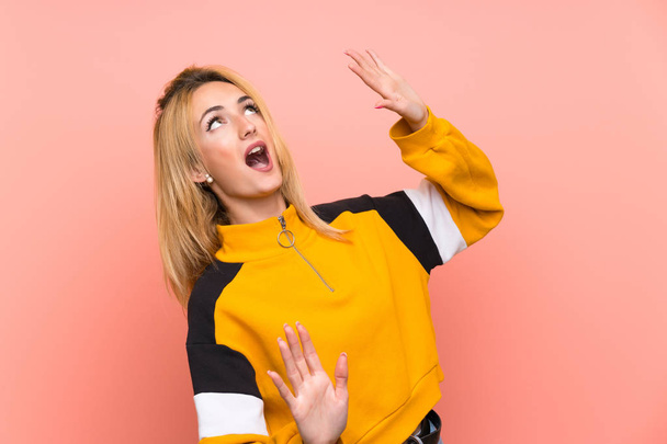 Young blonde woman over isolated pink background nervous and scared - Foto, Imagen