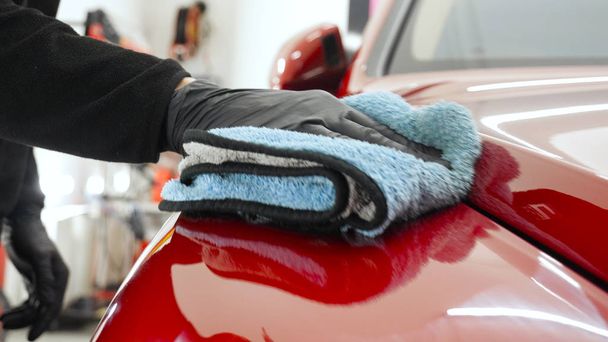 Closely shown as a professional worker polishes the transport (car) body using a polishing tool (machine). Concept from: Auto service, Car Painting, Machine washing. - Foto, Imagem