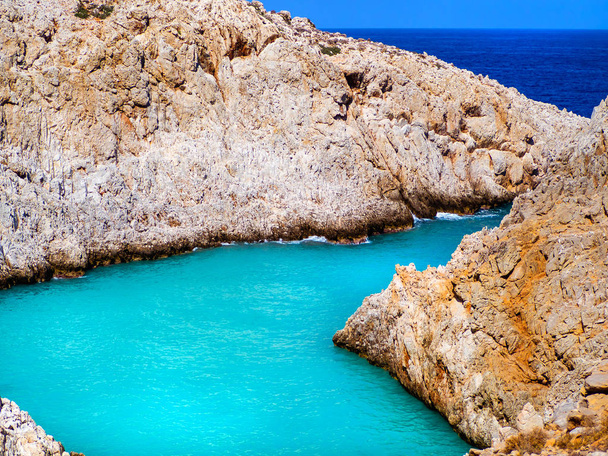 Εκπληκτικό φωτεινό γαλάζιο νερό σε έναν απομονωμένο όρμο με πορτοκαλί βράχια που το περιβάλλουν-Κρήτη, Ελλάδα - Φωτογραφία, εικόνα