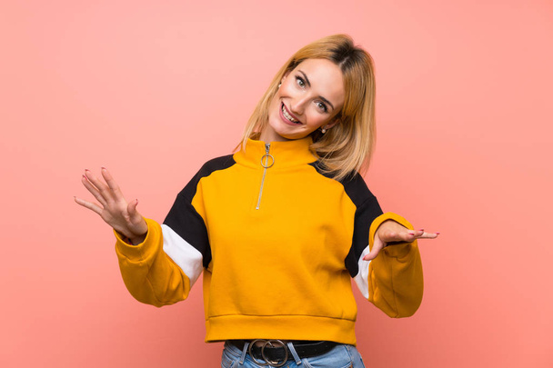 Young blonde woman over isolated pink background smiling - Fotó, kép