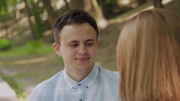 Beautiful happy couple in love sitting on a bench in the park and talking. - Filmagem, Vídeo