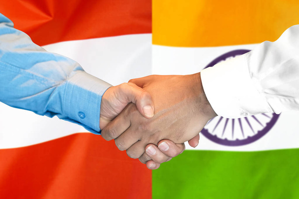 apretón de manos sobre el fondo de la bandera de Austria e India
. - Foto, imagen