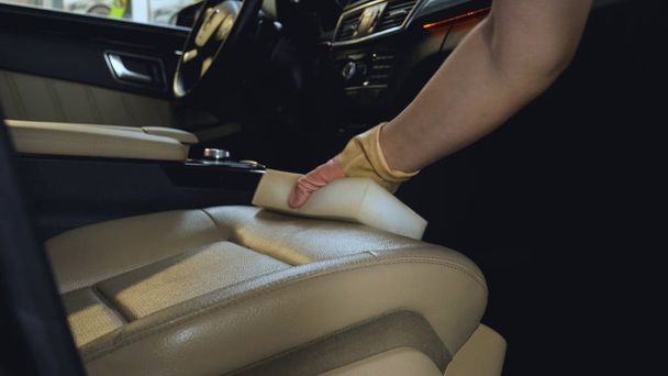 Dry cleaning of black mats for cars, vacuum cleaner removes dirt, pink rubber gloves, car washing. - Foto, Imagem