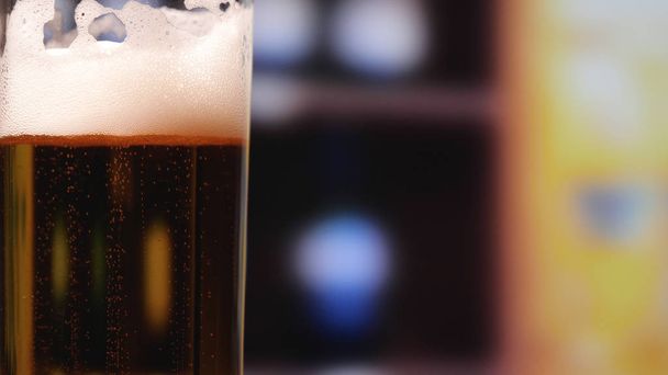 Kylmä lasi kevyttä olutta baaritiskillä. Lasi olutta pimeässä pubissa. Baarimikko on paikalla.
 - Valokuva, kuva