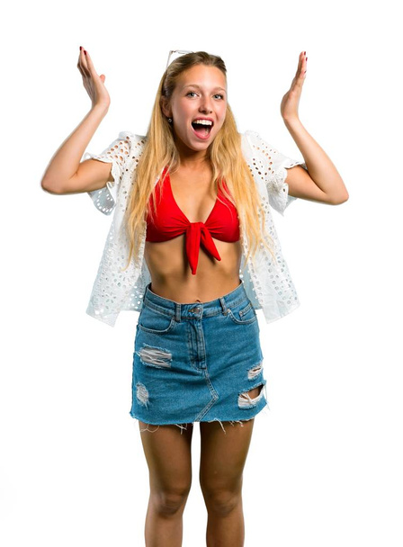Blonde girl in summer vacation with surprise and shocked facial expression on isolated white background - Фото, изображение