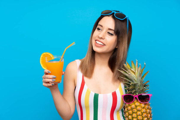 Young woman in summer holidays over blue background with cocktail - Fotoğraf, Görsel