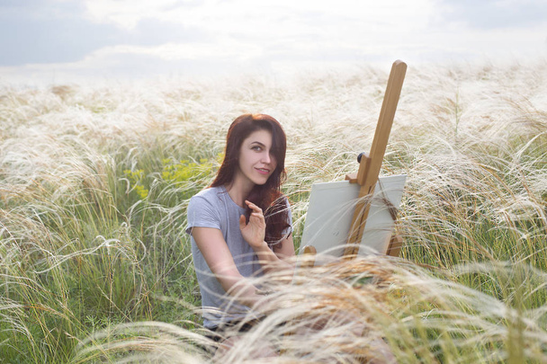 красива жінка малює на природі з мольбертом на полотні
 - Фото, зображення