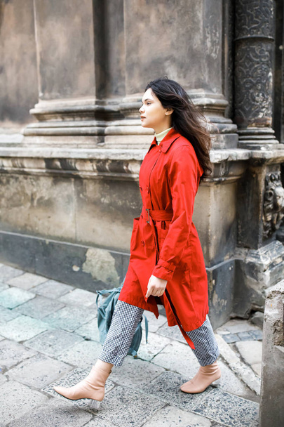 Piękna Brunetka młoda kobieta ubrana w płaszcz i chodzenie na ulicy - Zdjęcie, obraz