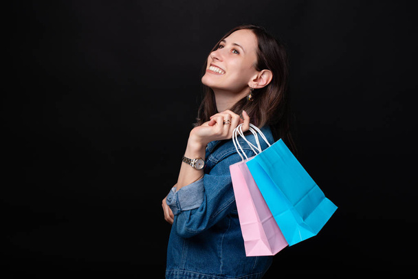 Retrato de mujer sonriente en casual con coloridas bolsas de compras
 - Foto, imagen