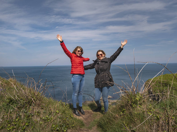Δύο ευτυχισμένα κορίτσια στην ακτή της Ιρλανδίας-ταξιδιωτικές φωτογραφίες - Φωτογραφία, εικόνα