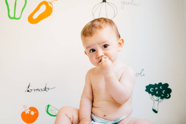 Dziecko, które bierze w ręce jedzenie, aby umieścić w ustach i jeść je. - Zdjęcie, obraz