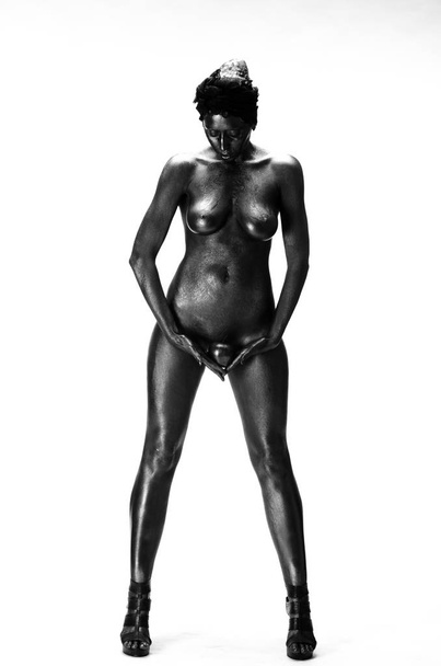 Naked woman painted in black on a white background in the studio - Fotoğraf, Görsel