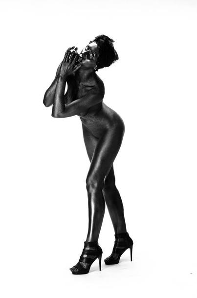 Donna nuda dipinta in nero su sfondo bianco in studio
 - Foto, immagini