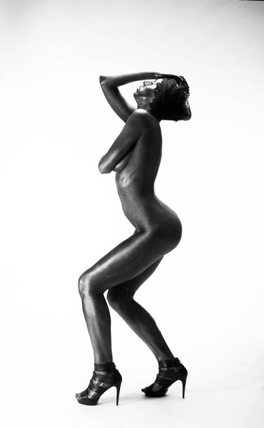 Naked woman painted in black on a white background in the studio - Foto, imagen