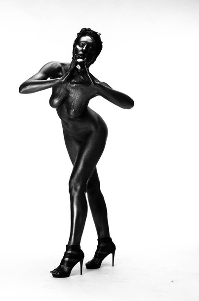 Çıplak kadın stüdyoda beyaz bir arka plan üzerinde siyah boyalı - Fotoğraf, Görsel