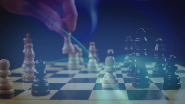 Digital composite of a man playing chess while glowing lights move in the background - Záběry, video