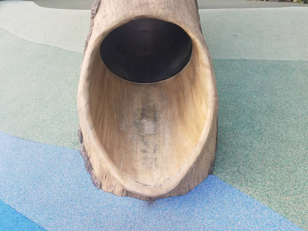 boom log dia op speelplaats met blauwe ondergrond - Foto, afbeelding
