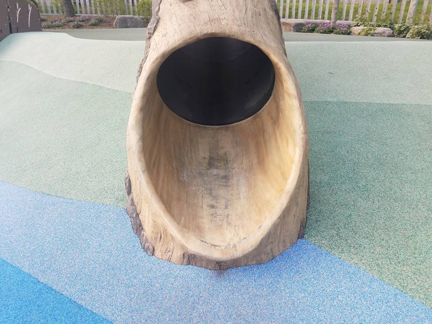 scivolo albero tronco sul parco giochi con superficie blu
 - Foto, immagini
