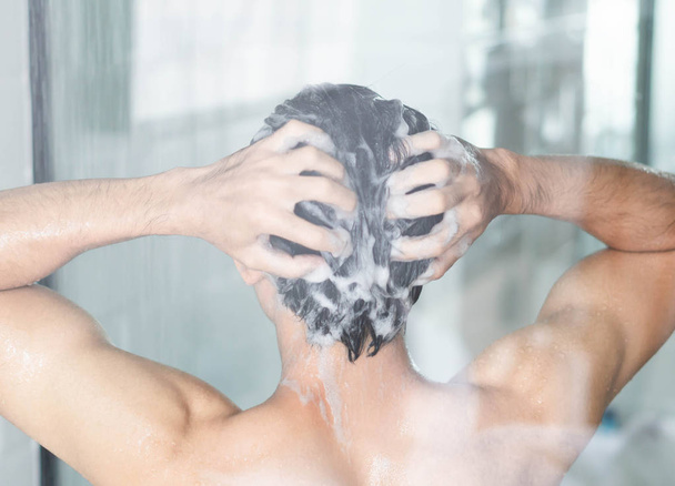 Primer plano joven lavando el cabello con champú en el baño, tono vintage, enfoque selectivo
 - Foto, imagen