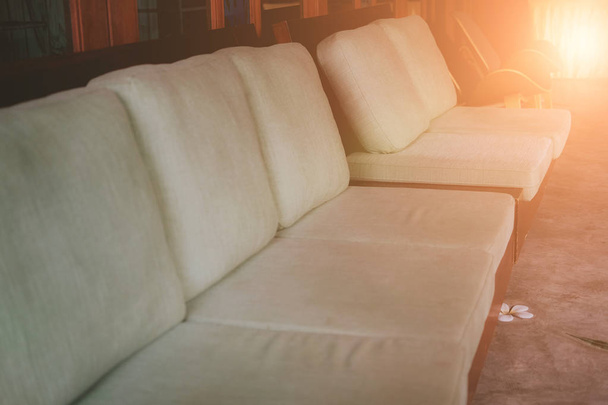 grünes Kissen auf einem hölzernen Sofa. Wohndesign für zu Hause  - Foto, Bild