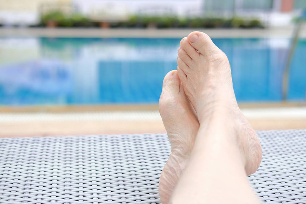 γυναίκα πόδια ξεκούραση δίπλα στην πισίνα.  - Φωτογραφία, εικόνα
