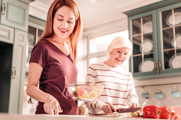 Beautiful female person helping her mom in kitchen - Foto, Imagen