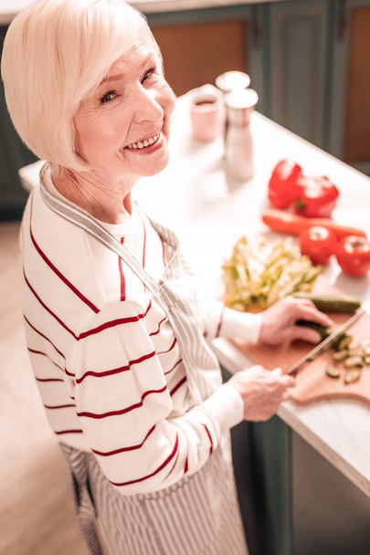 Mature female person preparing vegetables for salad - Photo, Image