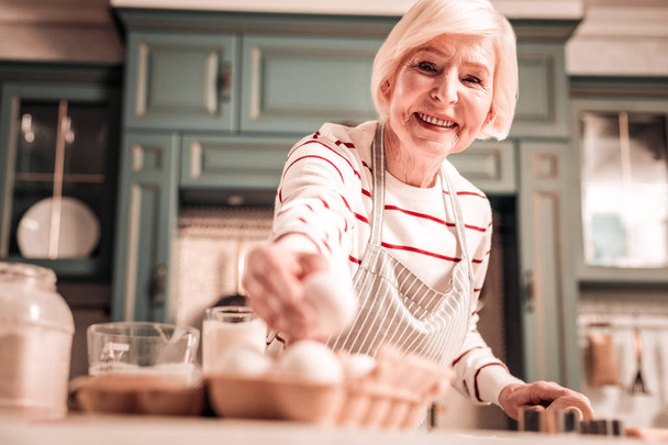 Positive delighted granny cooking biscuits for granddaughter - Foto, Imagem