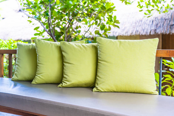 Φυτό βάζο στο τραπέζι διακόσμηση με μαξιλάρι στην πολυθρόνα καναπέ - Φωτογραφία, εικόνα