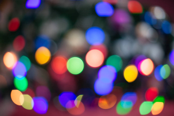 The Christmas tree is lit in different colors. Blurred background of the new year holiday - Foto, Imagen