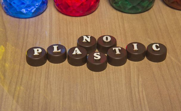 Nada de plástico. Inscripciones en letras de madera sobre tapas de botellas de plástico
. - Foto, Imagen