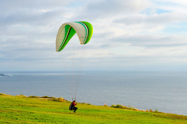 Adam spor yapıyor (para-planör). Bulutlu gökyüzünde bir adam yamaç paraşütü. Paragliding aşırı bir spor ve rekreasyon olduğunu. Torrey Pines Gliderport. San Diego 'da. Kaliforniya, ABD.  - Fotoğraf, Görsel