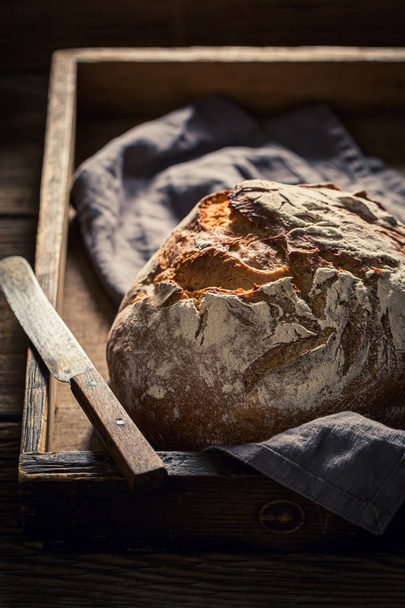 Tasty homemade loaf of bread on rustic table - Photo, image