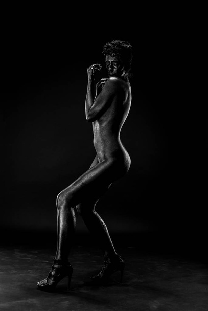 Nackte Frau schwarz auf weißem Hintergrund im Atelier. - Foto, Bild