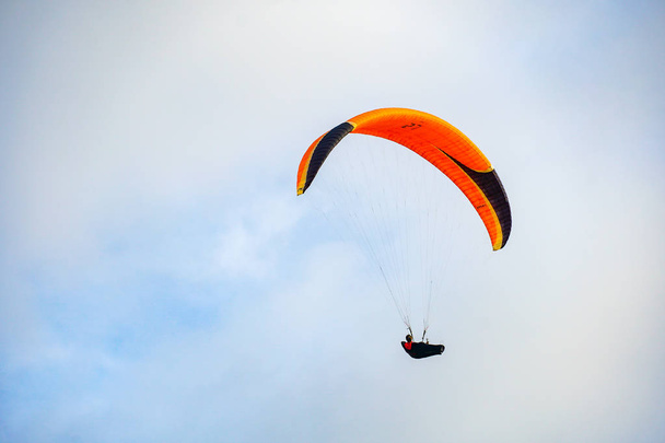 スポーツをしている男(パラグライダー)。曇った空をパラグライダーの男パラグライダーは極端なスポーツとレクリエーションです。トーリー・パインズ・グライダーポートサンディエゴ。カリフォルニア州,アメリカ合衆国.  - 写真・画像