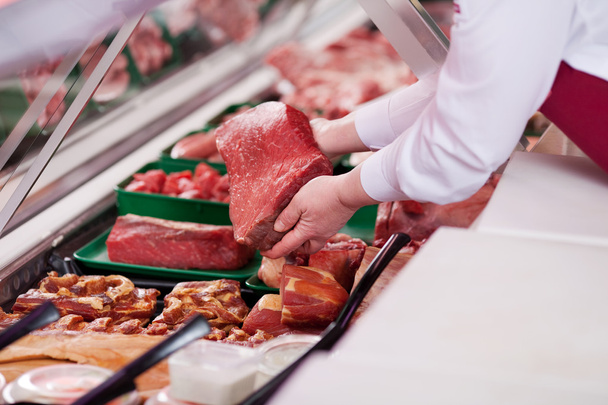 saleswoman offering fresh meat in supermarket - Фото, зображення