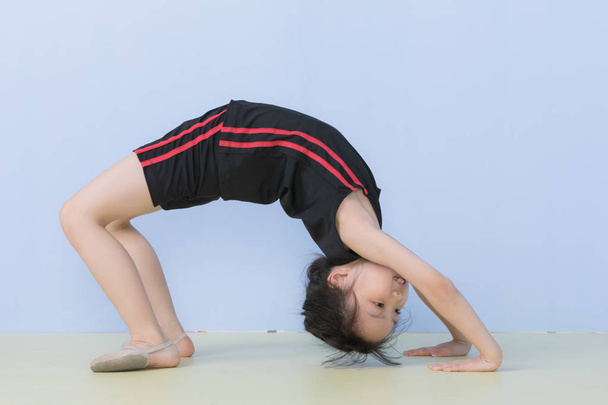 Asiatique fille en sportswear posant un pont pose
 - Photo, image