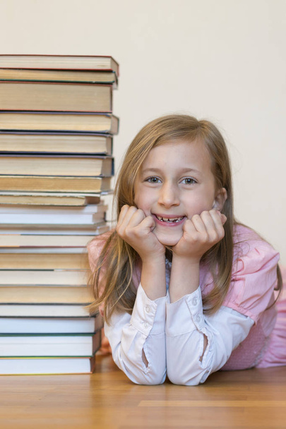 Happy schoolgirl with books in the room. vertical photo - Фото, изображение